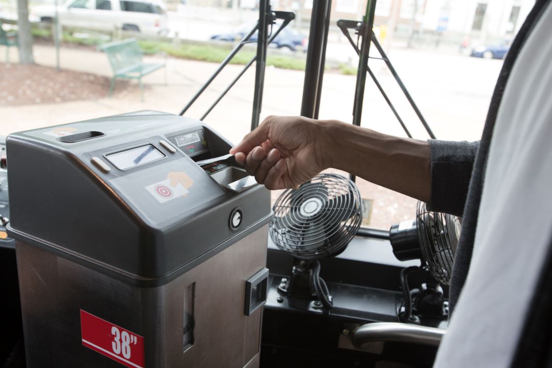 Fare care being inserted into fare box.